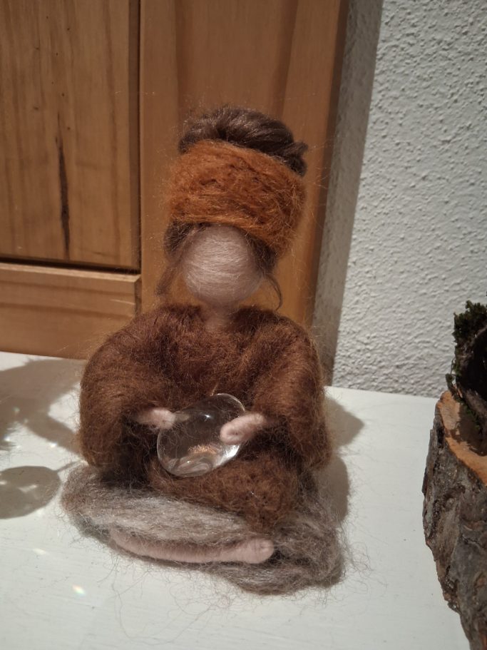 Die kleine Yogi hält einen Bergkristall in der Hand. Spirituelle Gedanken laden zum träumen ein. 